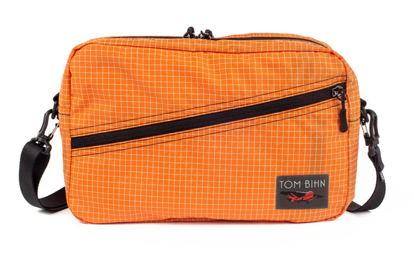 A Packing Cube Shoulder Bag in Zest (pale orange with white grid) 200 Halcyon with a 1-inch shoulder strap attached